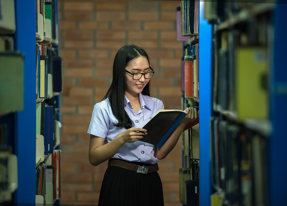 student reading book in library